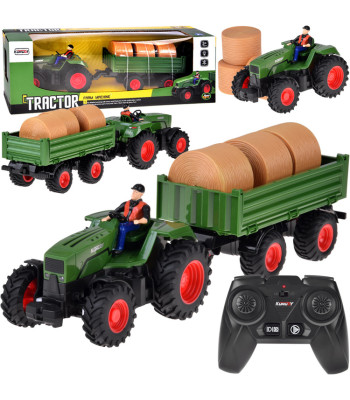 Kaugjuhitav traktor koos järelhaagise ja heinapallidega